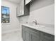 Laundry room featuring gray cabinets, white countertop, stainless steel faucet, and window at 4817 Majestic Hills Loop, Brooksville, FL 34601