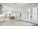 Bright and airy living room open to kitchen, showcasing an open floor plan and double-door access to the outside at 4817 Majestic Hills Loop, Brooksville, FL 34601