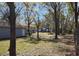 Large, partially fenced backyard with mature trees, garage, and home providing lots of space to enjoy at 5455 Lake Le Clare Rd, Lutz, FL 33558