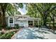 Backyard featuring a patio, screened-in porch, and mature trees providing ample shade at 5455 Lake Le Clare Rd, Lutz, FL 33558