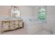 Elegant bathroom featuring a soaking tub, marble countertops, and decorative chandelier at 5455 Lake Le Clare Rd, Lutz, FL 33558