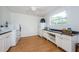 Bright laundry room with washer, dryer, utility sink, wood floors, countertop, cabinets, and window for natural light at 5455 Lake Le Clare Rd, Lutz, FL 33558