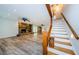 Open-concept living room with stone fireplace, wood beam, and staircase features hardwood flooring at 5455 Lake Le Clare Rd, Lutz, FL 33558