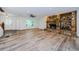 Bright living room with stone fireplace, wood-look flooring, ceiling fan and abundant natural light at 5455 Lake Le Clare Rd, Lutz, FL 33558