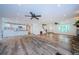 Spacious living room showcasing open floorplan, wood-look floors, kitchen access, and white paint at 5455 Lake Le Clare Rd, Lutz, FL 33558
