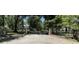Brick and iron gate entrance to the sprawling property with mature trees and lush greenery at 5455 Lake Le Clare Rd, Lutz, FL 33558