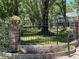 Property line with brick pillars, wrought iron fence, and flower beds showcasing the home at 5455 Lake Le Clare Rd, Lutz, FL 33558
