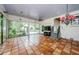 Large sun room offering a pendant lamp, clay flooring, outdoor access, a ceiling fan and lots of natural light at 5455 Lake Le Clare Rd, Lutz, FL 33558
