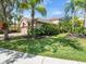 Front exterior view of a two-story home with a two-car garage, driveway, and lush landscaping at 7656 Portstewart Dr, Lakewood Ranch, FL 34202