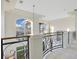 Upstairs landing with wrought iron railing and large windows at 1935 Lago Vista Blvd, Palm Harbor, FL 34685