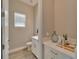 Small powder room with white vanity and tile floor at 2636 Yellow Sundial Loop, Ruskin, FL 33570