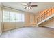 Living room with wood-look flooring, ceiling fan, and staircase at 1877 Pine Cone Cir, Clearwater, FL 33760