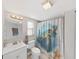 Bathroom features white cabinets, tile floors, and turtle themed shower curtain at 1155 7Th N St, Safety Harbor, FL 34695