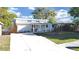 Inviting single-story home featuring a charming front porch and well-maintained lawn under a bright sky at 1155 7Th N St, Safety Harbor, FL 34695