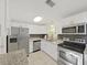 Modern kitchen featuring stainless steel appliances, granite countertops, and white cabinets, creating a stylish and functional space at 1155 7Th N St, Safety Harbor, FL 34695