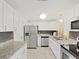 Modern kitchen featuring granite countertops, stainless steel appliances, and white cabinetry for a clean and stylish look at 1155 7Th N St, Safety Harbor, FL 34695