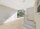 A partially covered patio provides access to the home's interior and a view of the fenced backyard and trees at 1155 7Th N St, Safety Harbor, FL 34695
