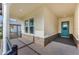 Covered porch with a brick floor leading to an attractive blue front door at 4638 Southern Valley Loop, Brooksville, FL 34601