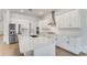 Modern kitchen features white cabinets, stainless steel appliances, and a large center island with a quartz countertop at 4638 Southern Valley Loop, Brooksville, FL 34601