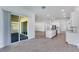 Open-concept living space with stainless steel appliances, white cabinetry and an oversized glass sliding door at 4638 Southern Valley Loop, Brooksville, FL 34601