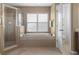Relaxing bathroom featuring a soaking tub beneath a window and a separate glass-enclosed shower at 7127 Forest Mere Dr, Riverview, FL 33578