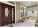 Covered front porch with bench seating, side table and view of green lawn at 7127 Forest Mere Dr, Riverview, FL 33578