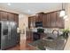 Stylish kitchen featuring stainless steel appliances, granite counters, and dark wood cabinets at 7127 Forest Mere Dr, Riverview, FL 33578