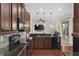 Well-appointed kitchen with dark cabinetry, granite countertops, and modern appliances at 7127 Forest Mere Dr, Riverview, FL 33578