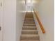 Carpeted staircase with wood railing leading to upper level at 9550 Tara Cay Ct # 17, Seminole, FL 33776