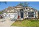 Charming single-story home featuring a two-car garage, neutral stucco exterior, and well-maintained landscaping at 26933 Carmen Pl, Lutz, FL 33559