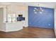 Open-concept living room with kitchen, dining area, blue accent wall, and modern light fixtures at 26933 Carmen Pl, Lutz, FL 33559