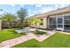 Spacious backyard with a patio, artificial turf, and a screened enclosure at 2989 Brookfield Ln, Clearwater, FL 33761