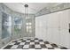 Eat-in kitchen with white cabinets, patterned wallpaper, and a checkerboard floor at 2989 Brookfield Ln, Clearwater, FL 33761