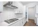 Modern kitchen showcasing white subway tile backsplash, stainless steel hood, and gas range cooktop at 4656 Southern Valley Loop, Brooksville, FL 34601
