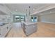 Open kitchen with gray island, white cabinets, and stainless steel appliances at 3812 W Sevilla St, Tampa, FL 33629