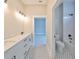 Bathroom with white cabinets, patterned floor and a bathtub at 3812 W Sevilla St, Tampa, FL 33629
