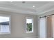 Bright bedroom featuring two windows, carpeted floor, and barn door at 3812 W Sevilla St, Tampa, FL 33629
