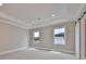 Well-lit bedroom with carpet, crown molding, and two windows at 3812 W Sevilla St, Tampa, FL 33629