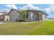 One-story home with gray exterior, attached garage, and landscaped yard at 927 Kelly Fern Loop, Ruskin, FL 33570