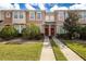 Two story townhome with red door and landscaped lawn at 6950 Towering Spruce Dr, Riverview, FL 33578