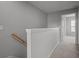 Upstairs hallway with carpeted floor, neutral walls, and a half wall leading to bedrooms at 6950 Towering Spruce Dr, Riverview, FL 33578