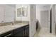 Modern bathroom with dark vanity, granite countertop, and double sinks at 19433 Whispering Brook Dr, Tampa, FL 33647