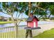 Bird feeder hanging on tree overlooking lake and homes at 19433 Whispering Brook Dr, Tampa, FL 33647