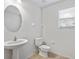 Simple bathroom with pedestal sink, toilet, and window at 19433 Whispering Brook Dr, Tampa, FL 33647