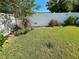 Landscaped backyard with a white fence and green lawn at 7723 Mitchell Ranch Rd, New Port Richey, FL 34655