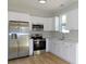 Kitchen featuring stainless steel appliances, bright white cabinets and floors, and a view from the window at 1010 E Flora St, Tampa, FL 33604