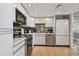 Efficient kitchen featuring white cabinetry, stainless steel appliances, and mirrored backsplash for a modern touch at 800 S Gulfview Blvd # 903, Clearwater Beach, FL 33767