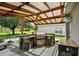 Outdoor kitchen with stone and granite finishes under a pergola at 6228 Dainty Bess Ct, Land O Lakes, FL 34639