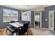 Modern dining room with dark wood table, gray walls, and home office access at 6228 Dainty Bess Ct, Land O Lakes, FL 34639