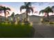 Single-Gathering home with a well-manicured lawn and palm trees at dusk at 9295 Butler Blvd, Weeki Wachee, FL 34613